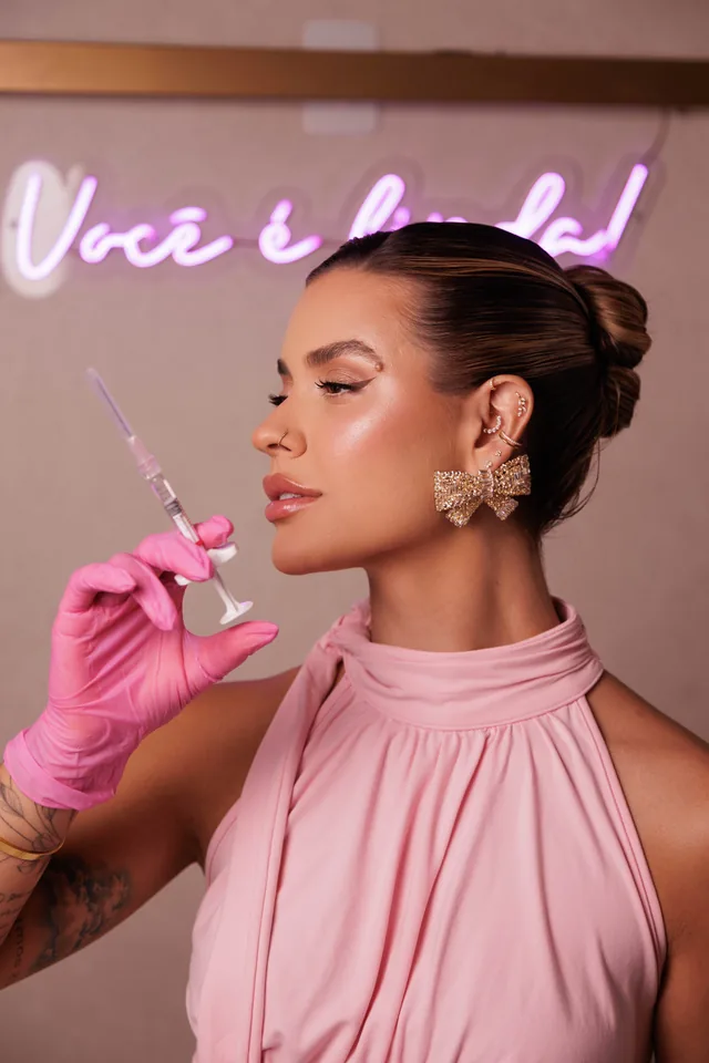 Julia Helenas com luvas rosa e seringa